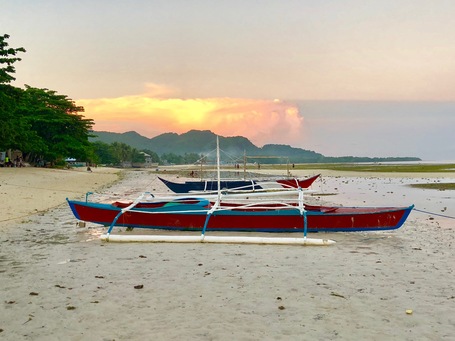 Ein Banka Boot am Strand von Anda im Sonneuntergang.