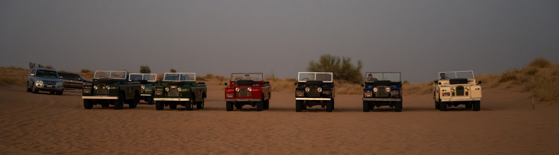 The Land Rovers of the desert tour at sunset