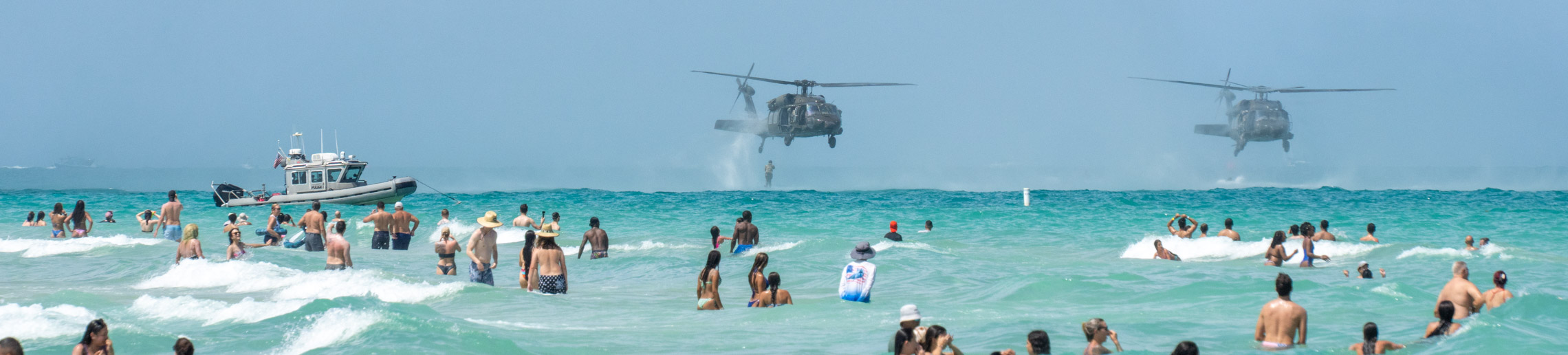 Two American military helicopters dropping personnel into the water during the Sea and Air Show in Miami Beach