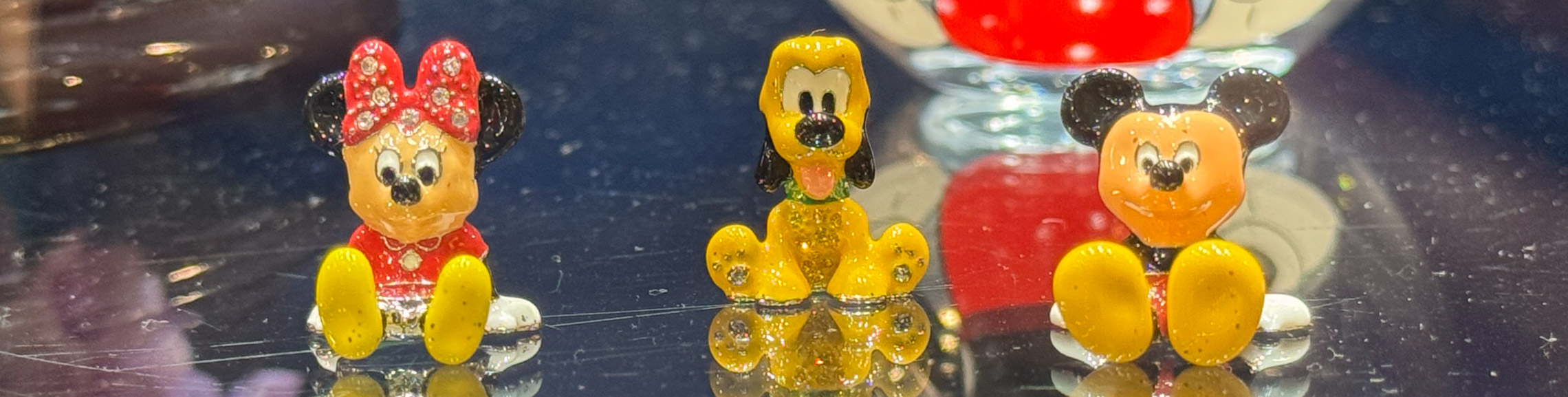 Miniature figures of Mickey, Minnie, and Pluto just a few millimeters tall