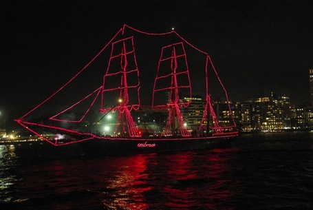 Segelboot geschmückt mit pinken Lichterketten und dem Wort embrace auf der Seite