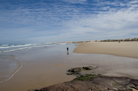 Distanzfoto vom Sandstrand. In seichtem Wasser ca 100m entfernt steht meine Mutter